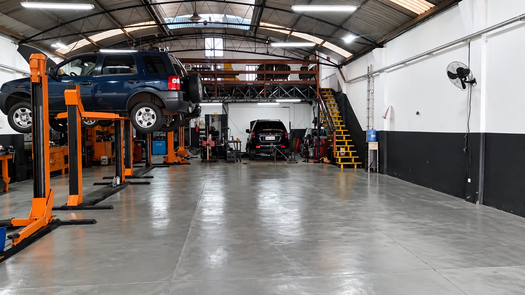 Interior da Mecânica Precisão, com elevadores e carros em manutenção
